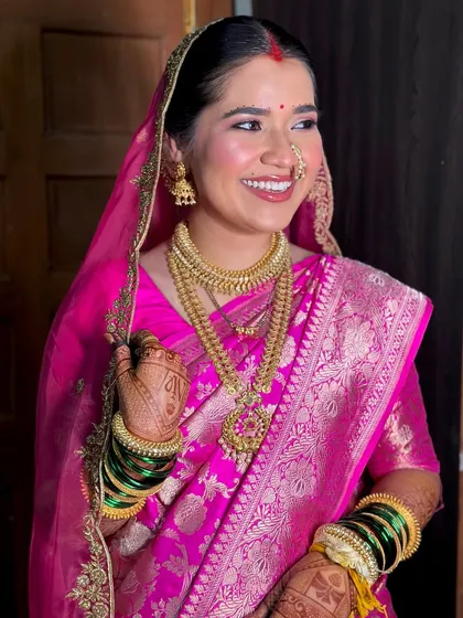 A radiant smile from my Maharashtrian bride. The gold jewelry and the vibrant pink of her Banarasi silk saree are beautifully complemented by a luminous and fresh makeup look.