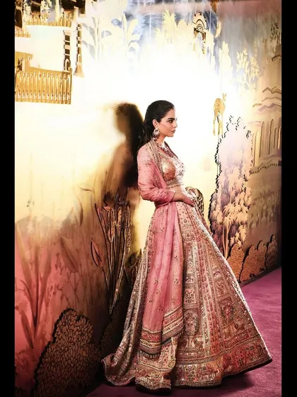 A side view of the Tarun Tahiliani lehenga against a beautifully painted wall. The setting enhances the artistic and ethereal quality of the ensemble.