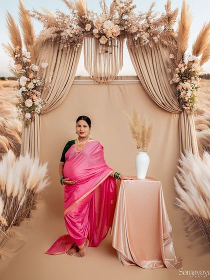 Here, I've blended traditional attire with a modern, bohemian setup. The pink saree looks stunning against the pampas grass and draped fabric, showing how we can mix styles.