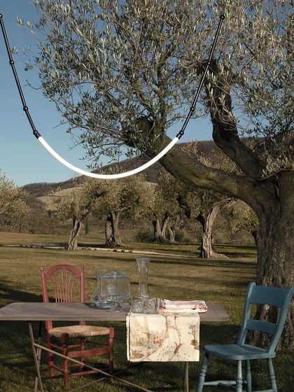 The Leda system is hung from a tree, providing whimsical and practical lighting for an outdoor gathering.