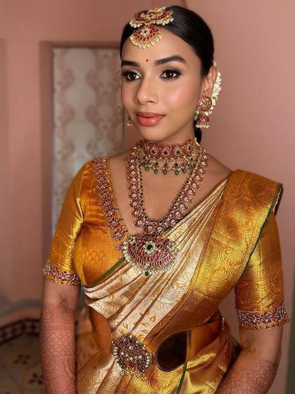The complete look, with her hair pulled back neatly to showcase the intricate jewelry and the flawless, glowing makeup.