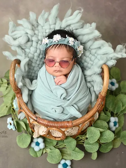 Cool, calm, and collected. This little diva rocks a pair of sunglasses while swaddled in a basket, a fun and stylish take on a classic newborn portrait.
