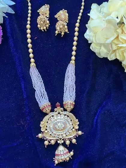 The product shot of the long necklace with a Kundan pendant and light pink beads. It comes with matching jhumka earrings for a complete look.