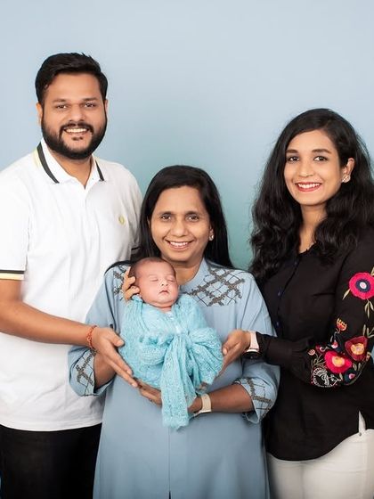 A precious moment as a grandmother holds her new grandchild, surrounded by the proud parents. Multi-generational photos are treasures that last a lifetime.