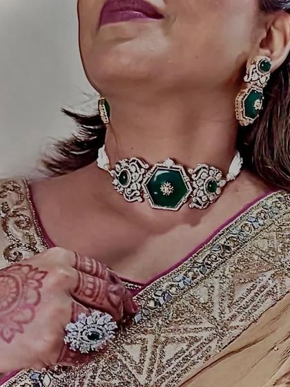 A close-up of the client wearing the green choker with a matching ring. The hexagonal design is modern yet traditional.