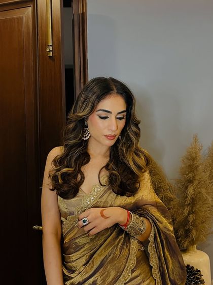 Another look at my self-designed golden saree. The soft waves in my hair and the classic makeup let the outfit be the star of the show.