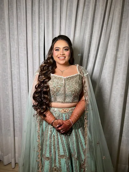 A full-length portrait showing the long, flowing curls. This style is ideal for brides who want to wear their hair down for one of the events.