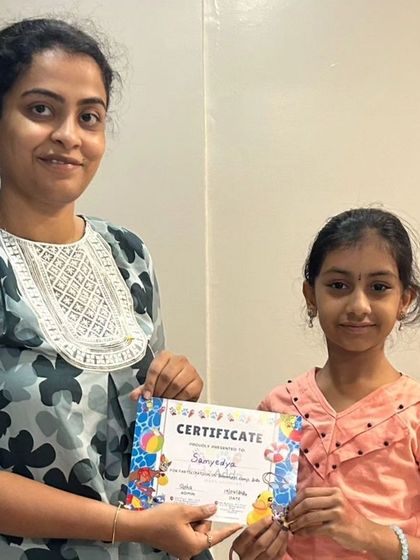 Another proud camper receives her certificate, marking the successful completion of the first batch of our summer camp.