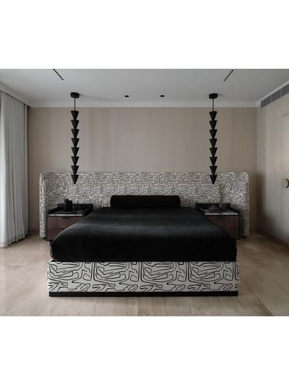 The master bedroom at The Grove Residence is a statement in monochromatic design. The graphic fabric and sculptural pendant lights create a strong visual impact in this modern luxury bedroom.