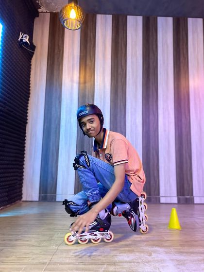 This student is posing with his inline skates after mastering a new technique. His focus and determination are an inspiration.