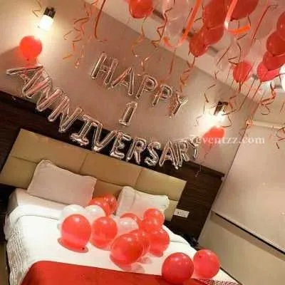 A simple and sweet first-anniversary room surprise with red and white balloons and "Happy Anniversary" foil letters.