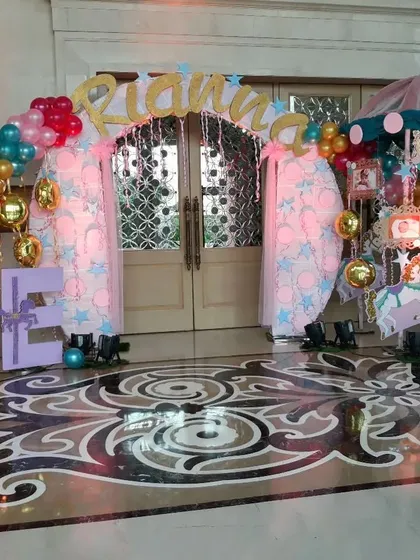 A grand carnival and carousel themed entrance. This elaborate setup features a custom name arch, carousel horse props, and balloon arrangements to create the feel of a funfair.