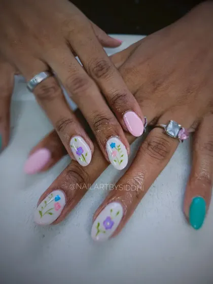 A sweet and simple design with hand-painted pastel flowers on a white base, paired with solid pink and green nails.