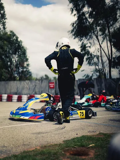 A driver stands by his kart, a moment of calm before the race.