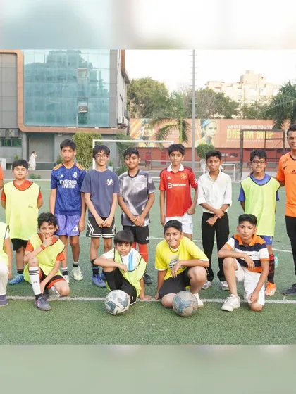 The two teams pose with their coach before the big game at Rudraneel's football-themed birthday party.