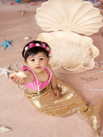 A charming shot of our little mermaid offering a seashell, set against a backdrop of pearls and starfish in our studio.