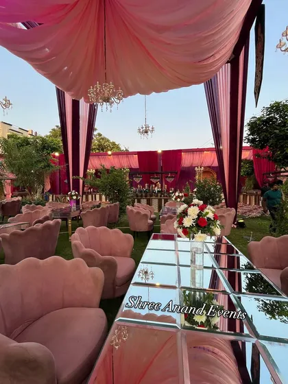 Elegant pink shell-backed chairs and mirrored tables create a chic and modern seating area for a daytime event.