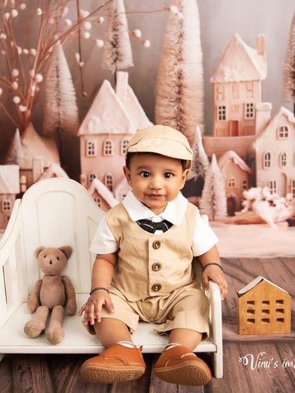 A dapper little gentleman in a snowy town. This sitter session portrait showcases a half-year milestone with a beautifully detailed winter-themed backdrop.