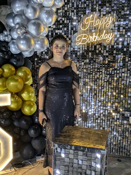 A close-up of a client enjoying her party, with the neon sign and sequin wall creating a beautiful, festive glow.