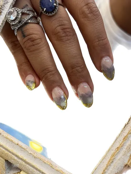 Another shot of the smoky watercolor nails with gold chrome tips, this time with a framed border. This highlights the almond shape and the intricate details of the art.