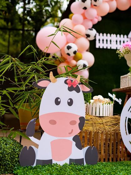 A friendly, life-sized cow cutout greets the little guests. I use these large, custom props to create a fun and interactive environment that delights children and provides wonderful photo opportunities.