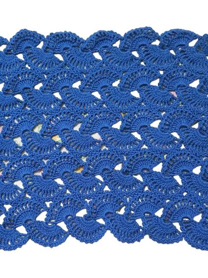The lacy stole in a rich royal blue. The intricate crochet work is clearly visible in this shot.