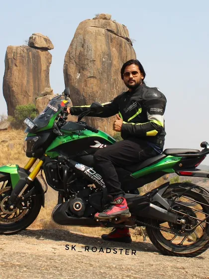 A rider posing on his green Dominar at Ramanagara, a popular spot for bouldering and biking.