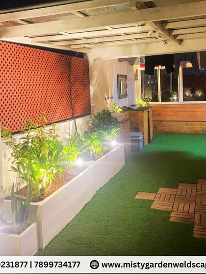 This view shows the clean, modern planters and comfortable seating arrangement on the terrace. The soffit panel ceiling and integrated lighting add a touch of luxury.