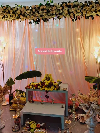 For a Gauri Maa puja, I designed this elegant and serene setup. It includes a beautiful floral arrangement overhead, soft peach drapery with subtle lighting, traditional banana leaves, and floor lamps to create a warm, divine atmosphere.