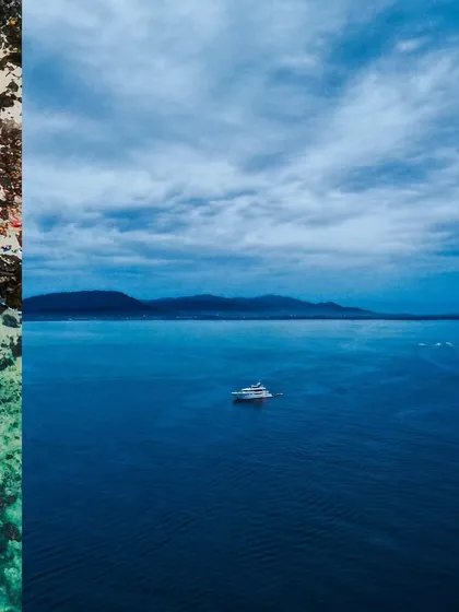 A solitary yacht on the vast, deep blue sea off the coast of Thailand, creating a sense of peace and isolation.