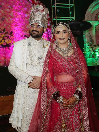 The happy couple posing for a picture on their wedding stage. They look so good together.
