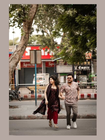 A fun, dynamic shot of a couple running and laughing across a city street, full of life and energy.