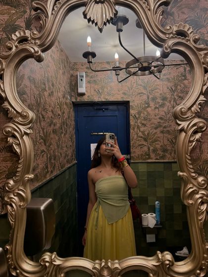 A mirror selfie showing how I styled the green top with a yellow maxi skirt for a vibrant, summery look.