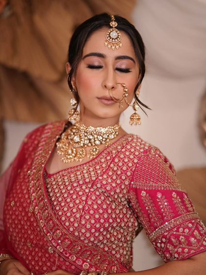 A complete bridal look featuring a heavy, gold-plated Kundan necklace, haath phool, and maang tikka, all available for rent.