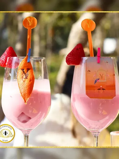 Two of our signature pink cocktails, garnished with fresh strawberries and a custom orange peel featuring the couple's initials. It's personalization at its finest.