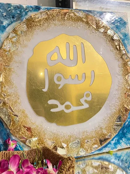 This luxury wall art features the Mohr e Nabuwat, or the Seal of Prophet Muhammad (PBUH). The design is set in gold and turquoise resin with a geode-like textured border, perfect for an exquisite living room.