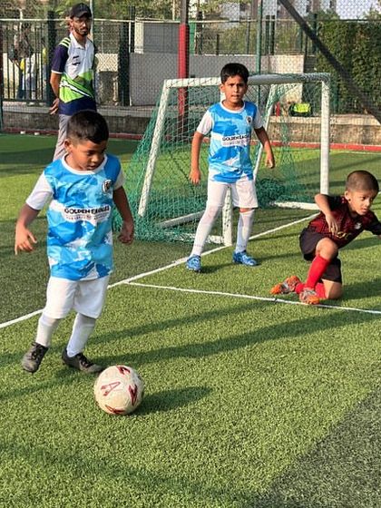 A Blue Cub player dribbles the ball, showing great focus. Our training for the U7 age group is designed to be fun while teaching core football skills.