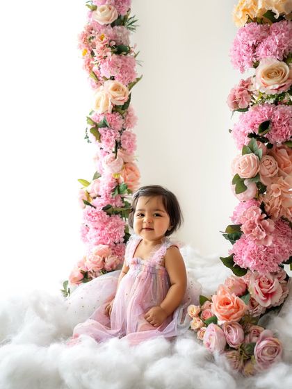 A dreamy floral swing session. This little girl looks like a fairy princess sitting among the clouds and flowers.