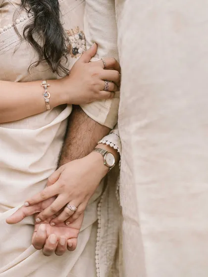 A close up on their intertwined hands. This detail shot is so telling, showing their connection and the beautiful details of their rings and attire.