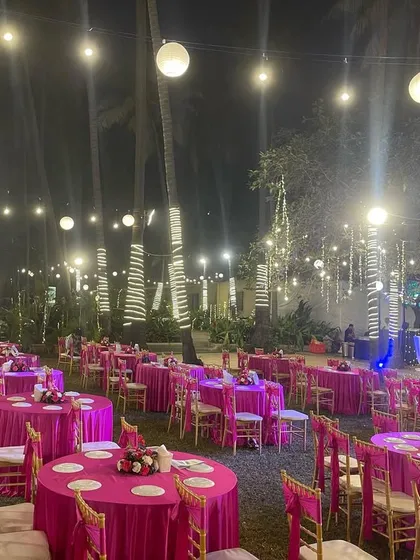 A vibrant pink-themed seating arrangement for an outdoor reception. The bold color choice for the tablecloths makes the entire venue pop, especially at night under the lights.