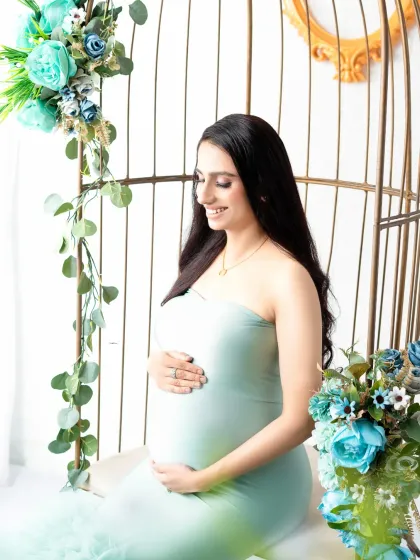 A tranquil moment in our birdcage chair set. The mother-to-be, in a soft mint green gown, is surrounded by beautiful blue and white floral arrangements.