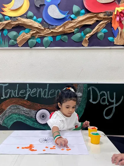 This young learner is engaged in a paper-pasting activity to create the Indian flag. It's a wonderful way to enhance hand-eye coordination and celebrate our country.