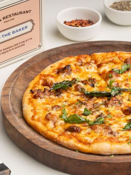 Another look at my chicken pizza, showcasing the golden, bubbly cheese and fresh basil leaves scattered on top.