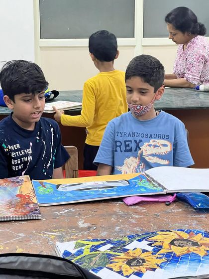 Art class is also a place for discussion and sharing ideas! Here, students discuss a Lamborghini drawing, inspiring each other with their interests and creations.