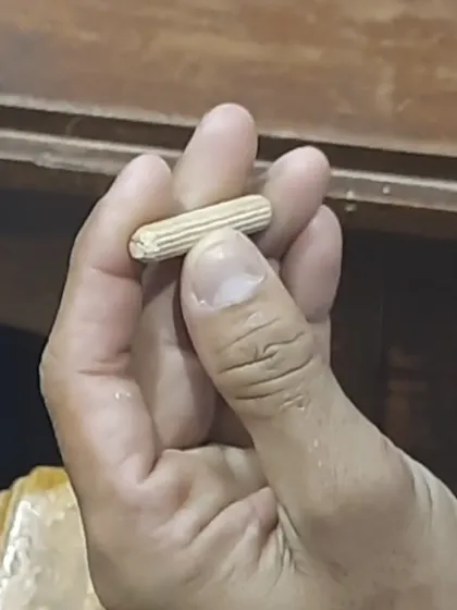 A close-up of a fluted wooden dowel. The flutes allow excess glue to escape and create a stronger mechanical bond within the joint.