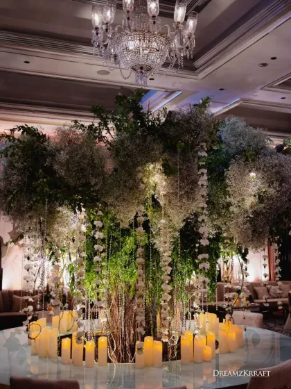 We brought the outdoors in for this stunning reception, centered around an iconic floral tree. Draped in baby's breath and crystal hangings, and surrounded by hundreds of candles, this installation transformed the ballroom into an enchanted forest.
