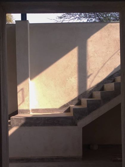 A framed view of the same staircase, seen through a doorway. The composition captures the abstract quality of light and shadow, turning a functional element into a piece of art.