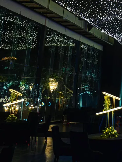 The reflection of the starry ceiling in the large glass windows of the venue, creating a seamless indoor-outdoor feel.
