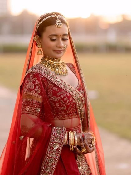 A moment of quiet reflection before the ceremony. Her makeup features soft, defined eyes and a flawless base, creating a look of serene beauty.