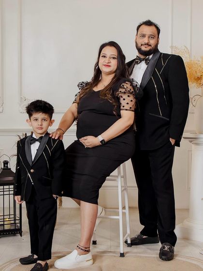A beautiful family portrait from a maternity shoot. The makeup is soft and natural, enhancing the mother-to-be's glow while coordinating with the family's formal attire.